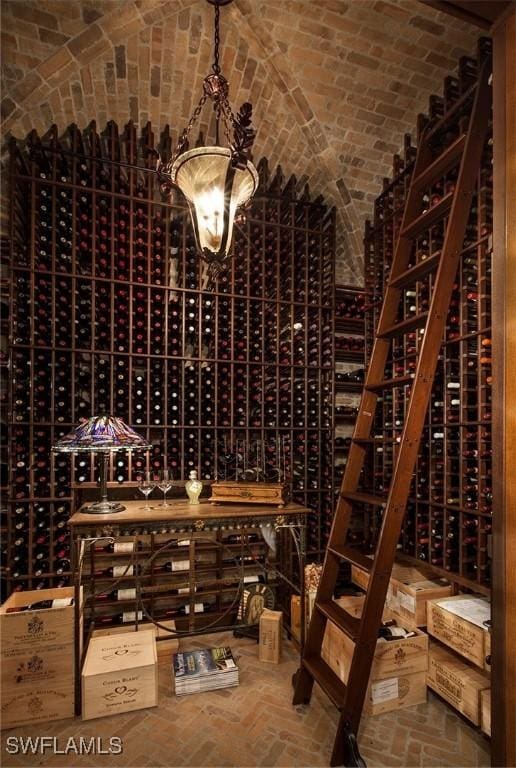 wine cellar featuring brick ceiling and vaulted ceiling