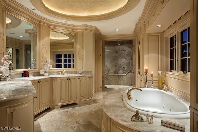 bathroom featuring a tray ceiling, crown molding, a washtub, and vanity