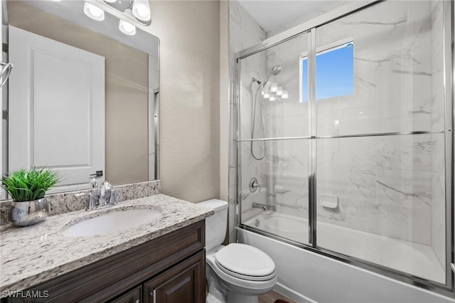 full bathroom featuring vanity, enclosed tub / shower combo, and toilet