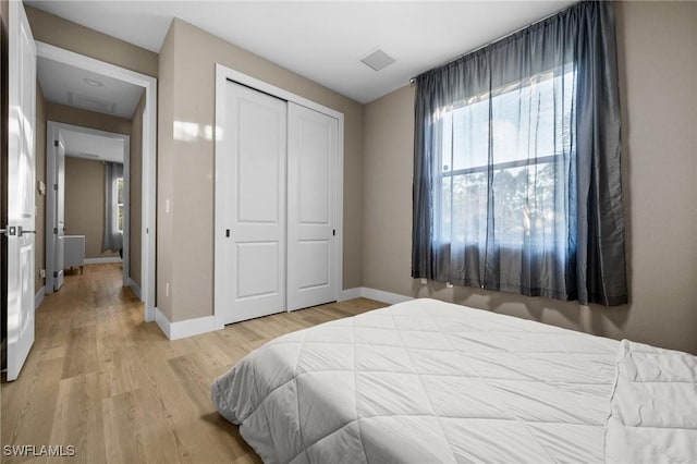 bedroom with light wood-type flooring and a closet