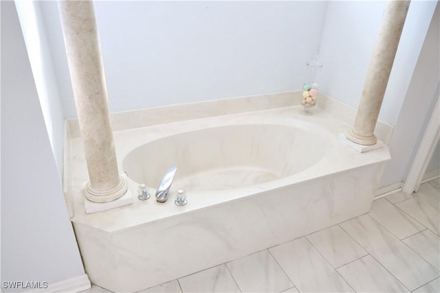 bathroom featuring a tub to relax in and decorative columns