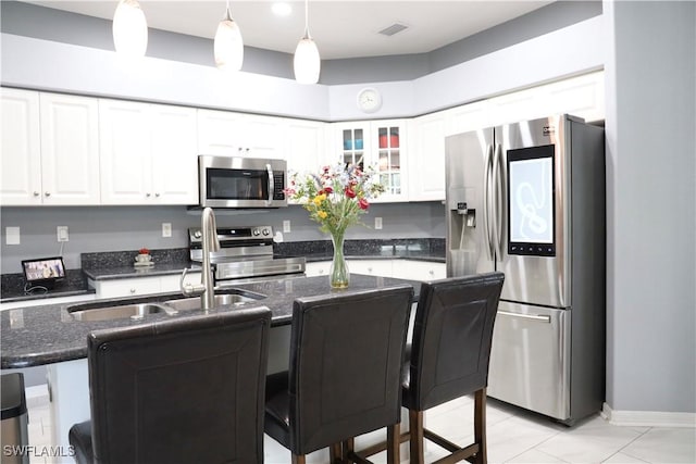 kitchen featuring hanging light fixtures, white cabinetry, and appliances with stainless steel finishes