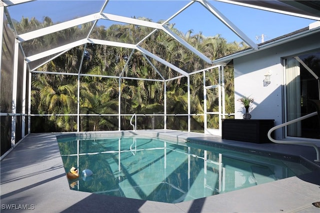 view of swimming pool featuring a lanai