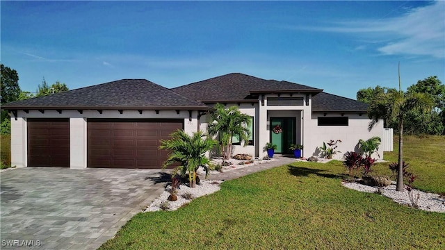 prairie-style house featuring a front yard and a garage