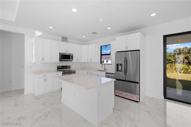 kitchen featuring sink, white cabinetry, a center island, and stainless steel appliances