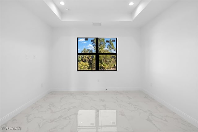 unfurnished room featuring a raised ceiling