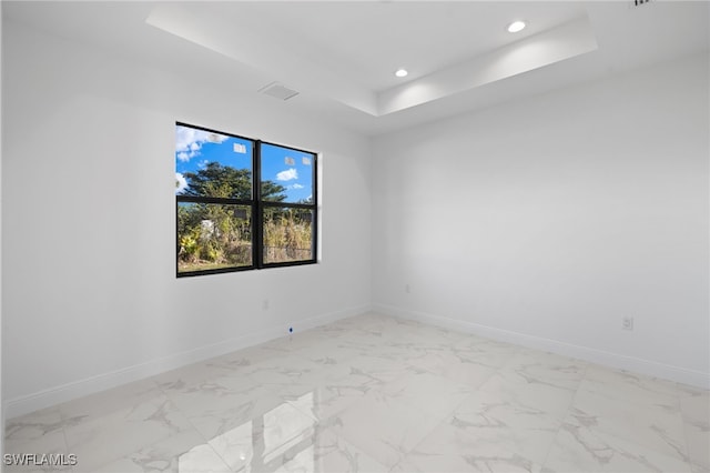 unfurnished room with a raised ceiling