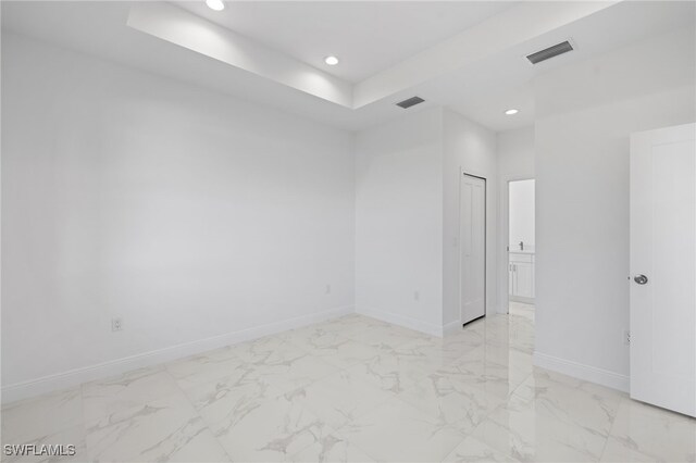 unfurnished room featuring a raised ceiling