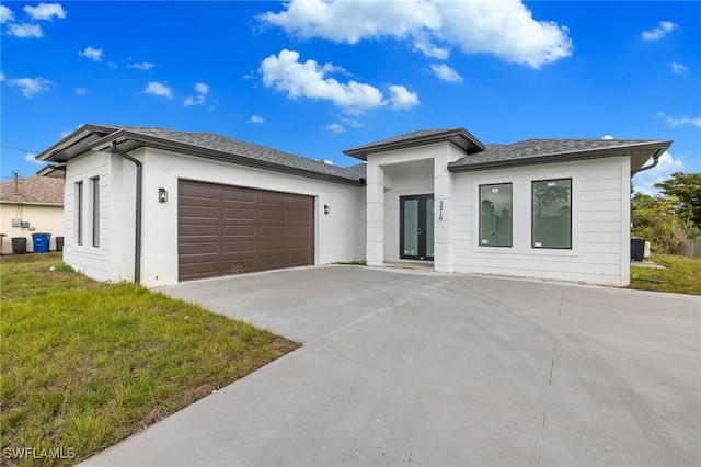 view of front of home with a garage and a front lawn