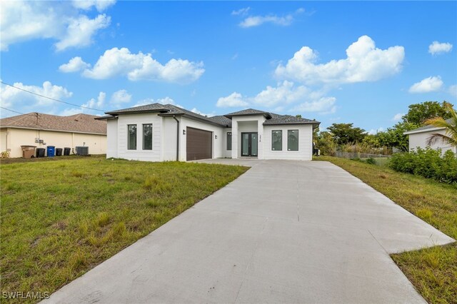 view of front of property featuring a front lawn and a garage