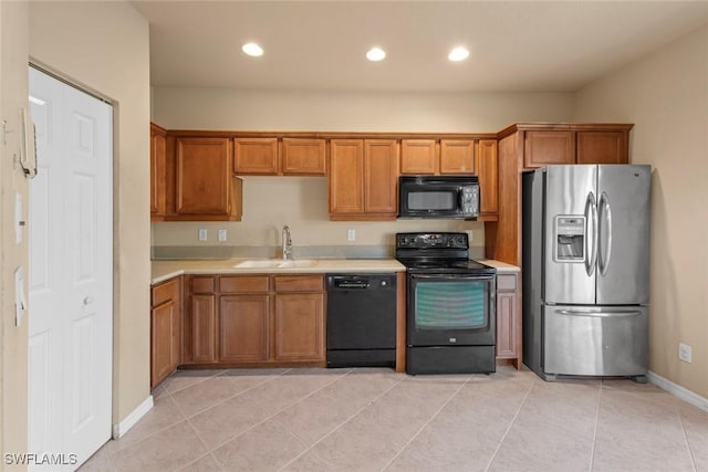 kitchen with light tile patterned flooring, sink, and black appliances