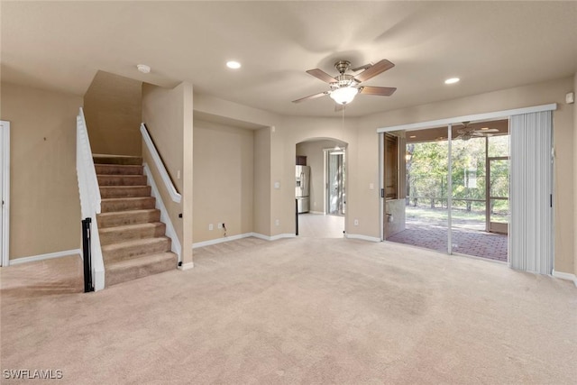 unfurnished living room featuring ceiling fan and light colored carpet