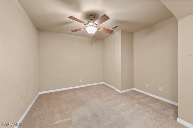 empty room with ceiling fan and light colored carpet