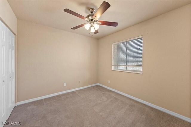 unfurnished bedroom with light carpet, a closet, and ceiling fan