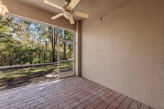 unfurnished sunroom featuring ceiling fan