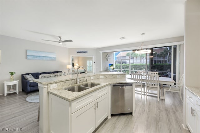 kitchen featuring pendant lighting, sink, white cabinets, and stainless steel dishwasher