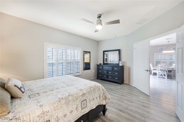 bedroom with visible vents, multiple windows, light wood-style flooring, and ceiling fan