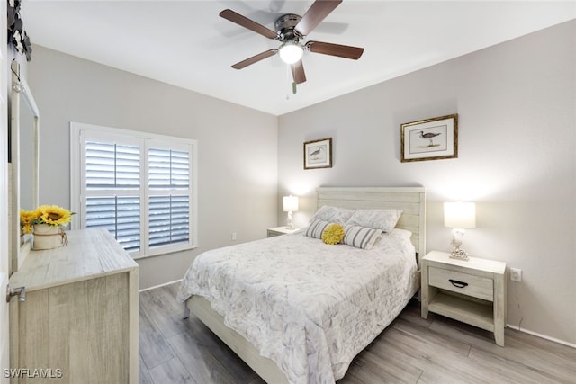 bedroom featuring light wood-type flooring, baseboards, and ceiling fan