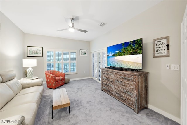 carpeted living room featuring a ceiling fan, visible vents, and baseboards