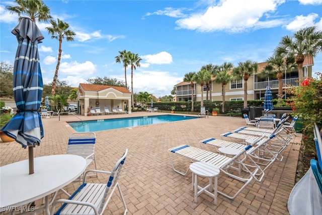 view of pool featuring an outbuilding and a patio