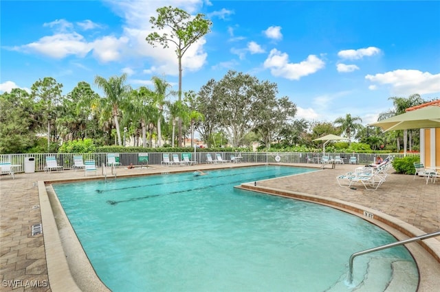 community pool featuring a patio and fence