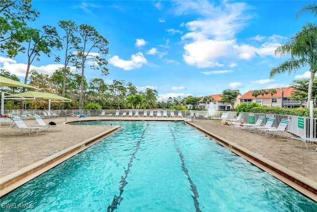 pool with a patio and fence