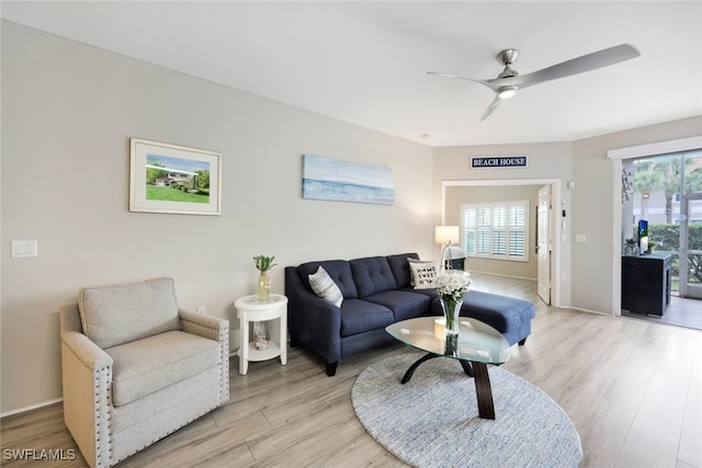 living room featuring plenty of natural light, ceiling fan, and light wood-type flooring