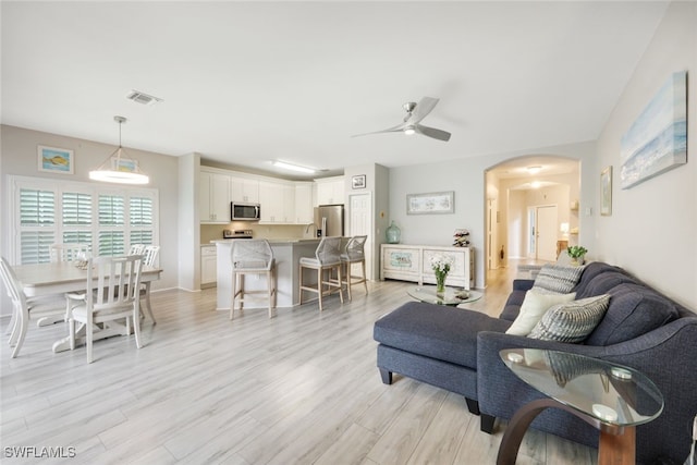 living room featuring ceiling fan and light hardwood / wood-style flooring