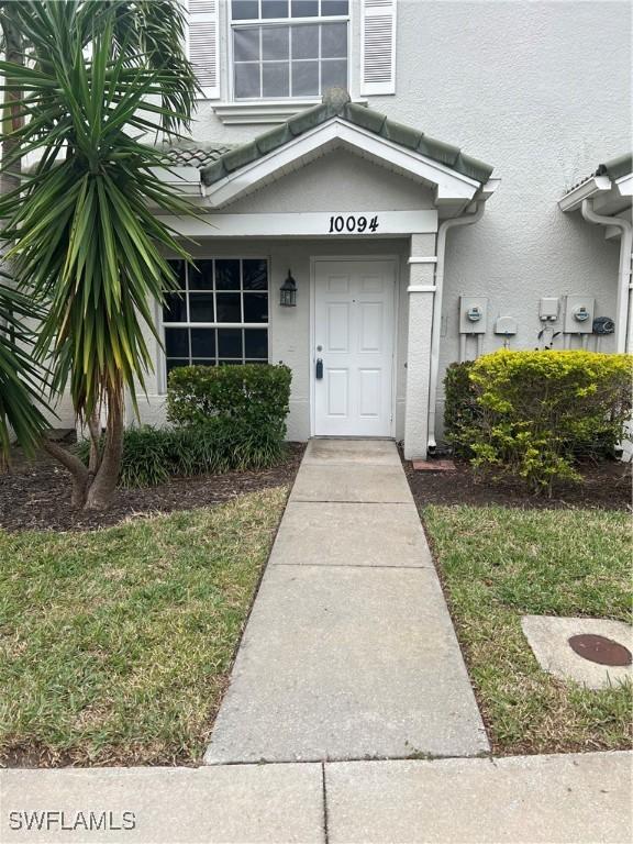 view of exterior entry with a yard