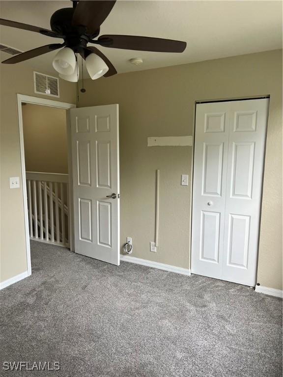 unfurnished bedroom with ceiling fan, a closet, and carpet