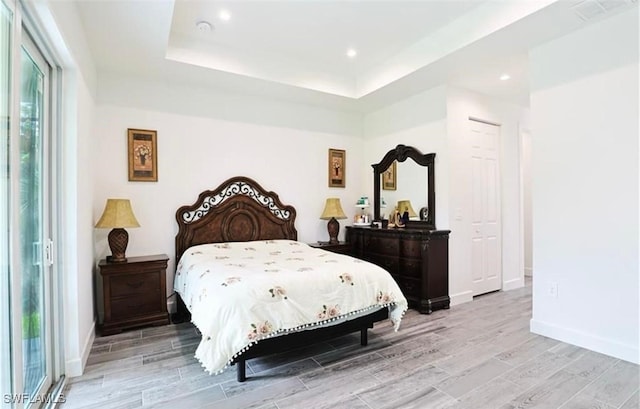 bedroom featuring a raised ceiling and access to outside