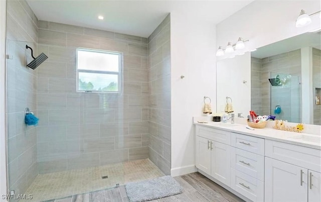 bathroom featuring tiled shower and vanity