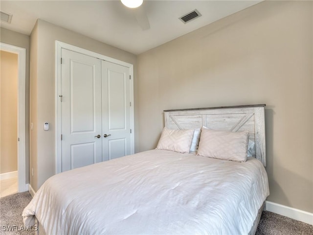 carpeted bedroom featuring ceiling fan and a closet