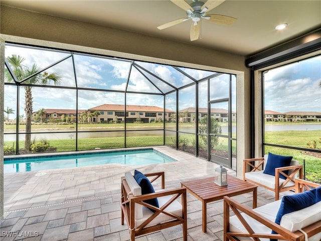 view of pool featuring ceiling fan, a water view, an outdoor living space, and glass enclosure