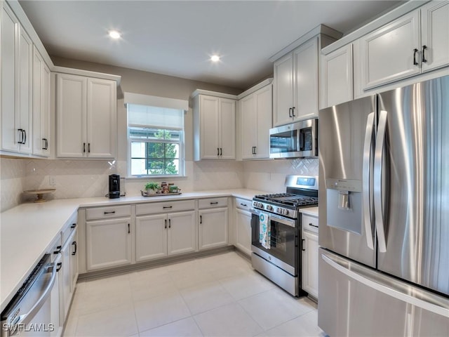 kitchen with white cabinets, backsplash, light tile patterned floors, and stainless steel appliances