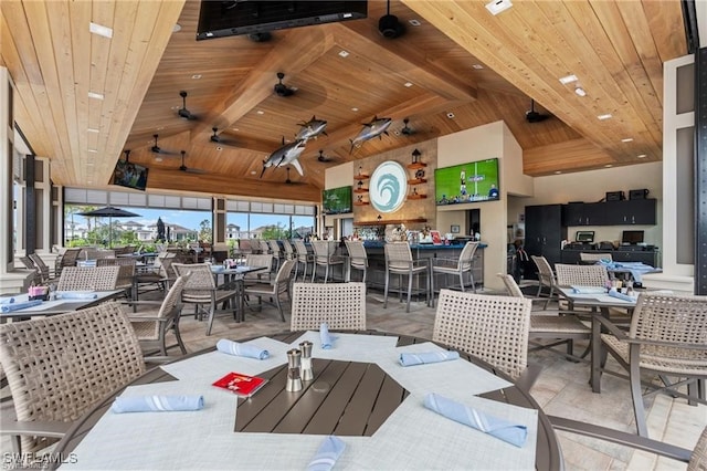 dining area featuring a wealth of natural light, high vaulted ceiling, ceiling fan, and wooden ceiling