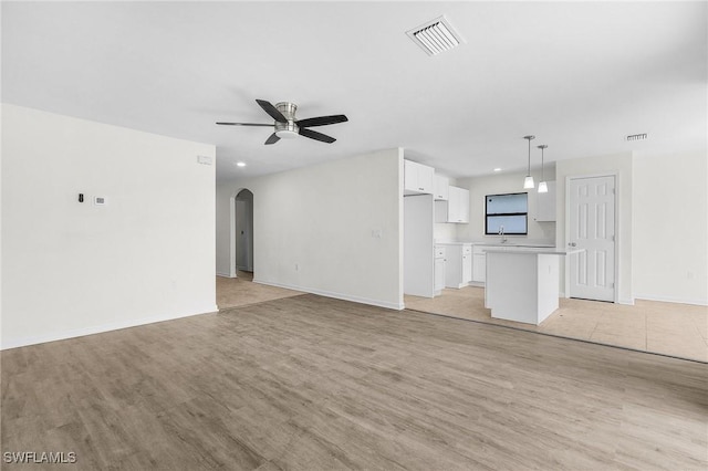 unfurnished living room with light hardwood / wood-style flooring and ceiling fan