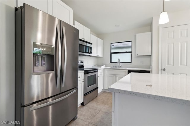 kitchen featuring appliances with stainless steel finishes, white cabinets, sink, pendant lighting, and light stone counters