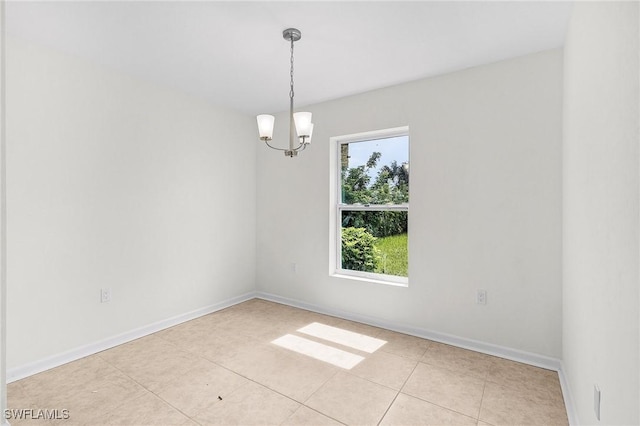 spare room featuring an inviting chandelier and light tile patterned floors