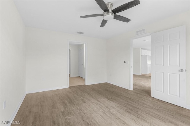 spare room with light wood-type flooring and ceiling fan