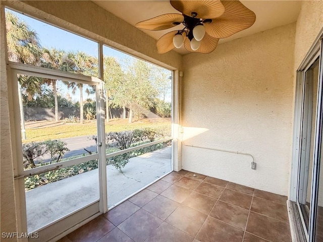 unfurnished sunroom with ceiling fan