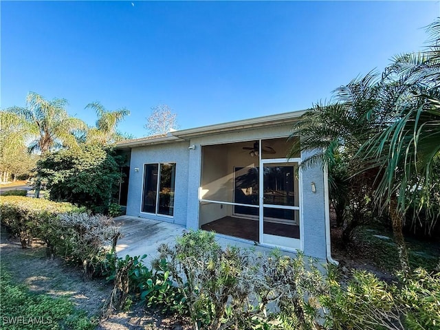 rear view of property featuring ceiling fan