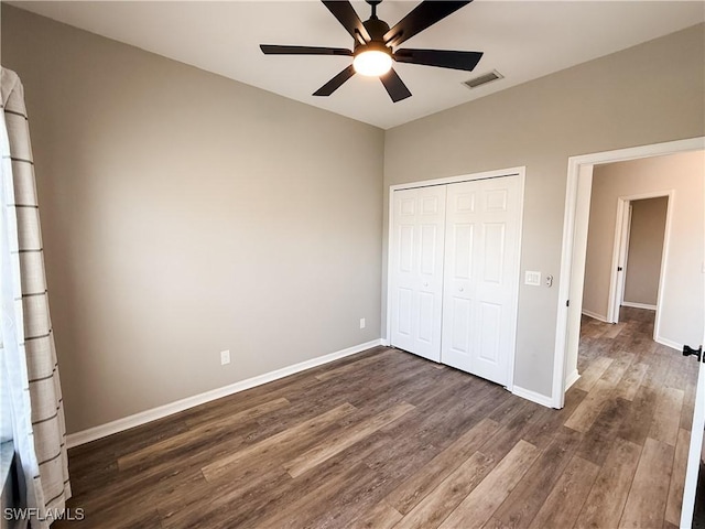 unfurnished bedroom featuring ceiling fan, dark hardwood / wood-style flooring, and a closet