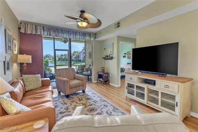 living room featuring light hardwood / wood-style floors and ceiling fan