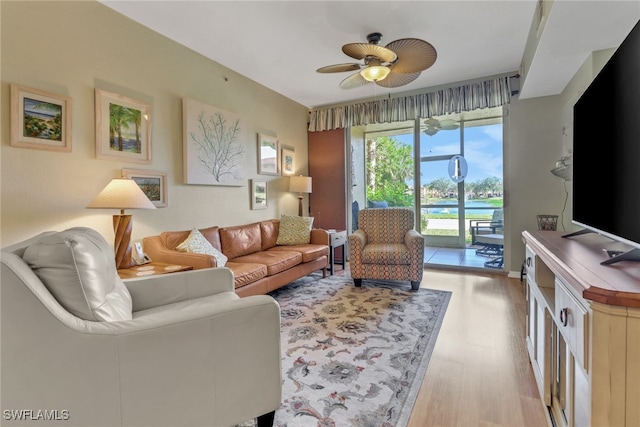 living room with light wood-type flooring and ceiling fan