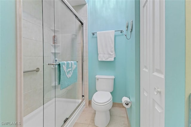 bathroom featuring tile patterned floors, toilet, and walk in shower