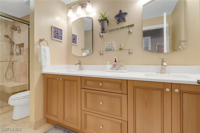 bathroom featuring tile patterned floors, vanity, toilet, and a shower with shower door