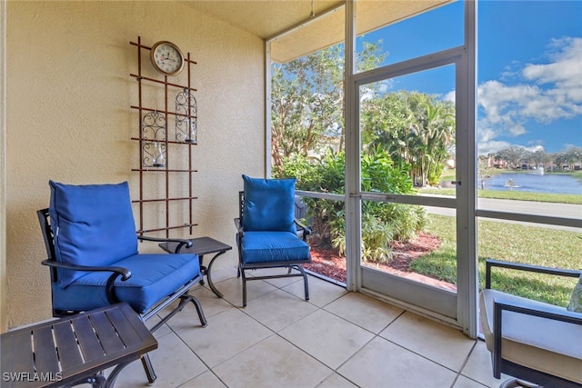 sunroom featuring a water view