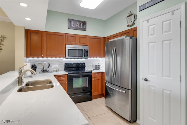 kitchen featuring tasteful backsplash, sink, light tile patterned flooring, and appliances with stainless steel finishes