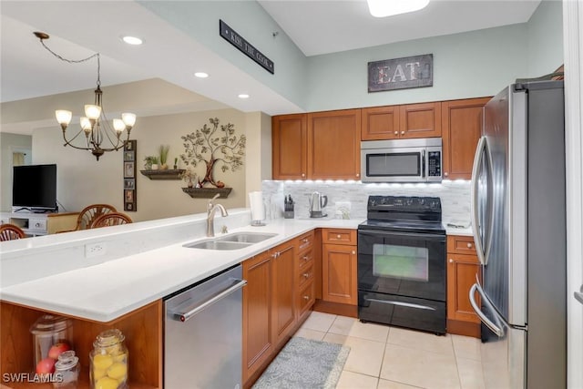 kitchen with kitchen peninsula, sink, a chandelier, and appliances with stainless steel finishes